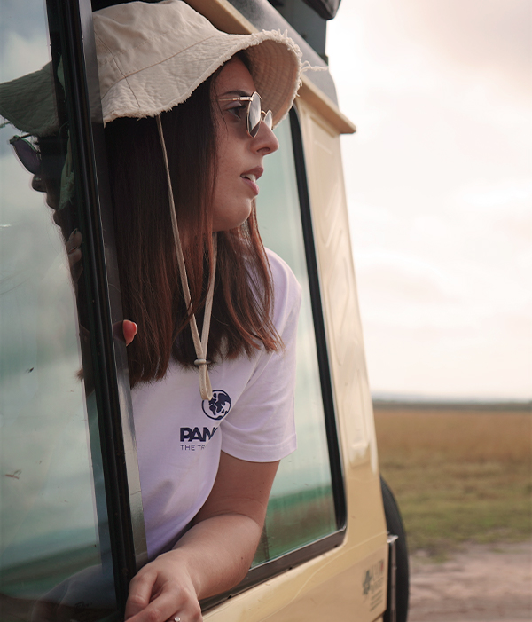 Imagen de una asesora con la camiseta PANGEA haciendo safari en Kenia mientras mira por la ventana de su 4x4